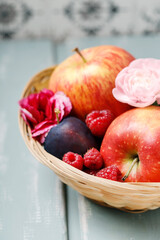 Wicker basket with various fruits on wooden table.