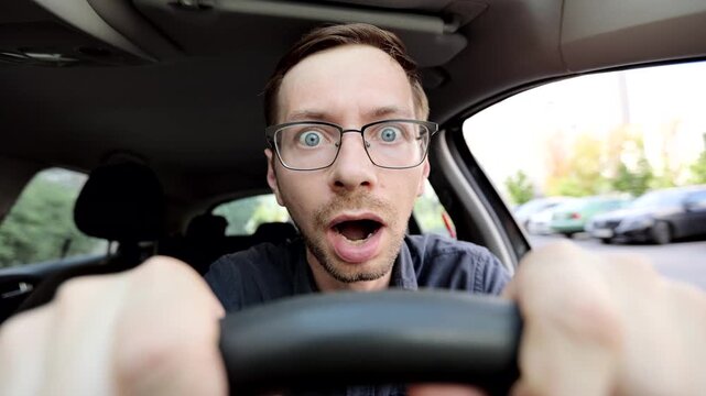 Young man driver shocked about to have traffic accident. Scared funny looking man driver in the car.