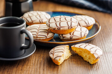 Sweet dessert with sugar coating on plate on wooden table.