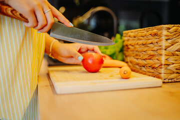 Young caucasian woman cutting vegetables in the kitchen


