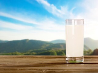A glass of fresh tasty milk on table