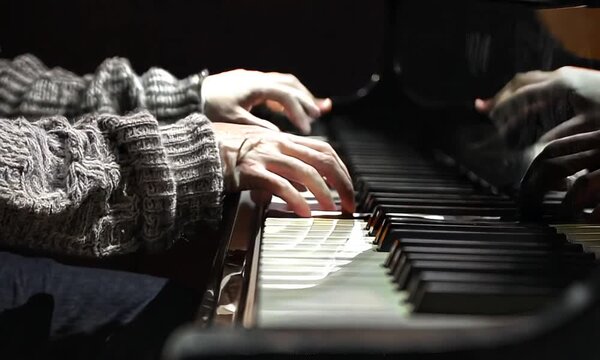 Hands of a child playing the piano keyboard