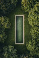 Aerial view of the long outdoor pool surrounded by green lawn and cypress trees