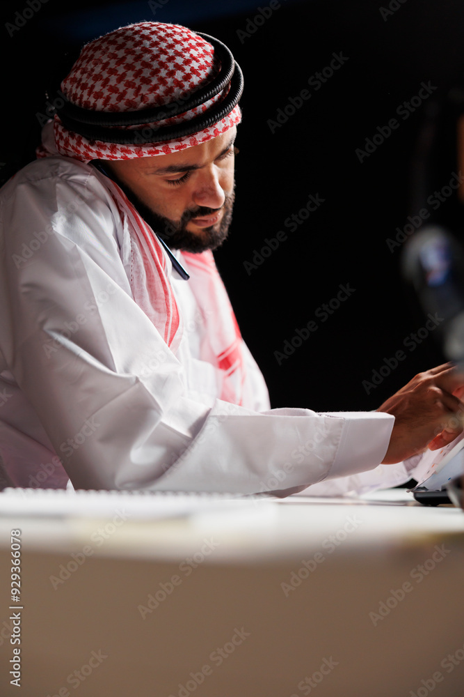 Aufkleber arab guy is seen in a close-up image utilizing a digital mobile device for study and communication. 