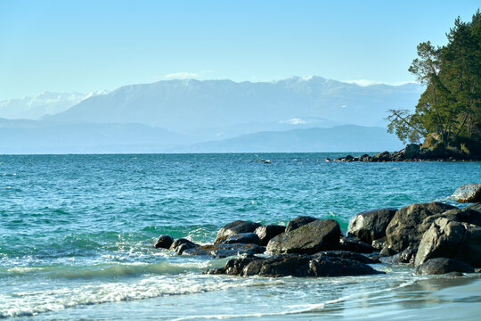 Vancouver Island Shoreline Rocks BC. A sandy beach and rocks on Vancouver Island overlooking the Strait of Juan de Fuca to the Olympic Mountains. 

