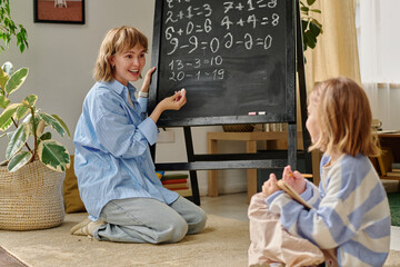 Happy proud mom and her kid having fun during doing sums