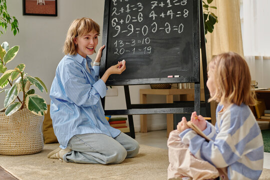 Happy proud mom and her kid having fun during doing sums