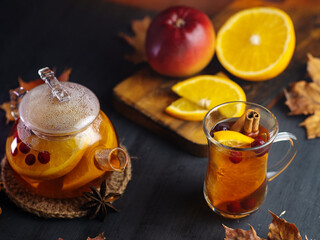 Spicy healthy fruit and berry autumn hot tea glass teapot with orange, apple, cranberries
