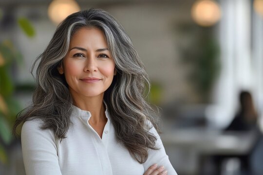 Accomplished Hispanic senior business woman standing.