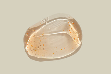 Cosmetic orange swatch of face wash soap foam cleansing gel with micro capsules isolated on beige background