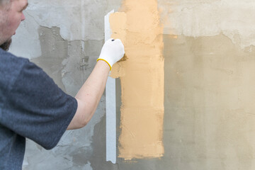 A man is painting a wall with a brush