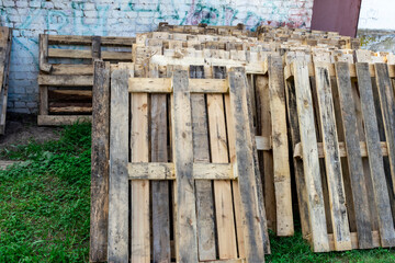 Fototapeta premium A pile of wood pallets are stacked in a yard