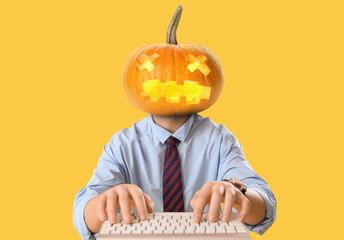Funny businessman using computer keyboard on yellow background, closeup