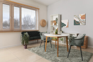 Beautiful living room with table, black cozy sofa and shelving unit