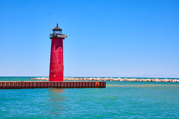 Red Lighthouse on Metal Pier Extending into Turquoise Waters at Eye Level
