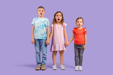 Fototapeta premium Shocked little kids on purple background
