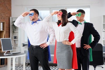 Business people dressed as superheroes in office