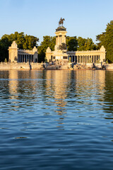 Retiro Park, Madrid, Spain. Crystal Palace, lake with swans, glass structure, architecture. Lake and temple on the horizon, fountains and decorated with colorful plants and flowers, family leisure.