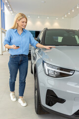 Smiling woman customer female buyer client choosing auto wants to buy new automobile in car showroom