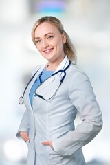 Happy beautiful doctor woman in uniform standing in medical office