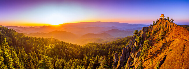 Summer sunrise over North Cascade ranges and a fire lookout over a cliff. © Lee