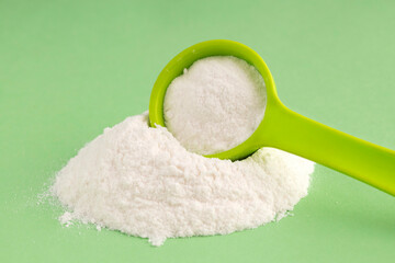 Baking soda powder in spoon - Healthy food. Green background
