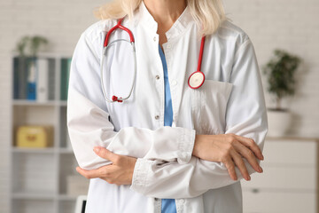 Female doctor with stethoscope in clinic, closeup