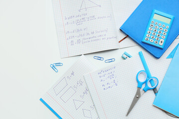 Copybooks with math formulas and different stationery on light table