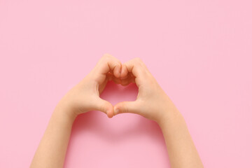 Fototapeta premium Child making heart with hands on pink background, closeup
