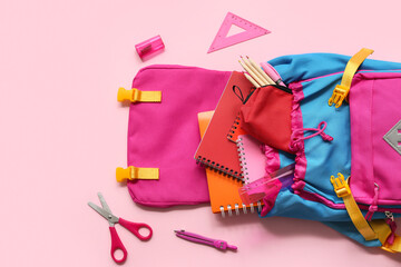 Modern school backpack with different stationery supplies on pink background