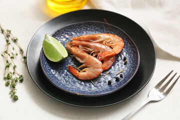 Plate with tasty boiled shrimps, lime and peppercorn on white background