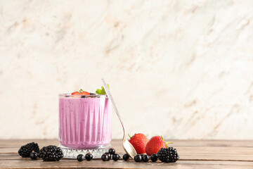 Glass of fresh smoothie with different berries and mint on wooden table