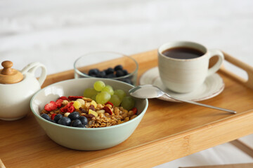 Tasty breakfast on tray in bedroom, closeup
