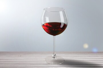 Red wine in glass on color background.