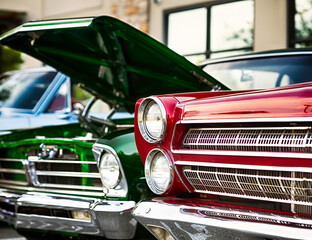 Two colorful 60s muscle cars on display at cruise-in. 