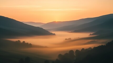 Obraz premium A long exposure shot of moving fog in a valley at dawn, with a faint orange glow from the rising sun