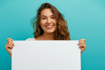 Fototapeta premium beautiful young woman on a blue background holding a white board with a place for an inscription. picture for advertising, woman encourages, advertises, generative AI