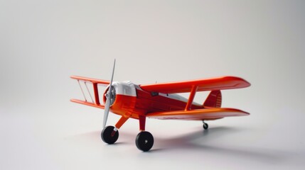 Red toy airplane model on a white background symbolizing travel, aspirations, and nostalgia