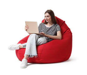 Beautiful young woman with laptop sitting on red bean bag chair against white background