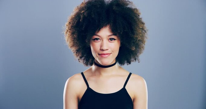 Face, smile and fashion with an afro woman in studio on gray background for style positivity. Portrait, model and trendy with a happy young person in a good mood in a clothes outfit for carefree joy