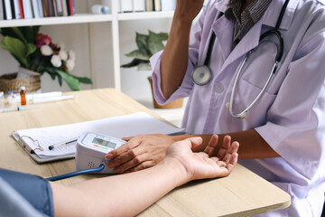 Close Up Of Patient And Doctor Hand Checking Blood Pressure Test With Machine