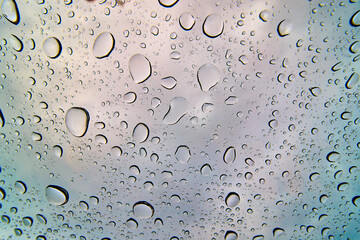 Water Droplets on Glass with Cloudy Sky Background Close-Up