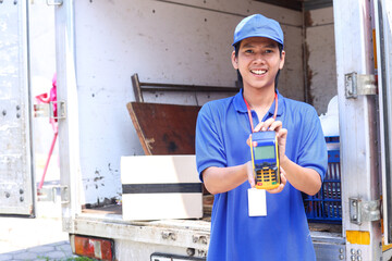 Asian deliveryman holding POS terminal. Delivery payment concept.