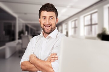 Smiling mature businessman using laptop.