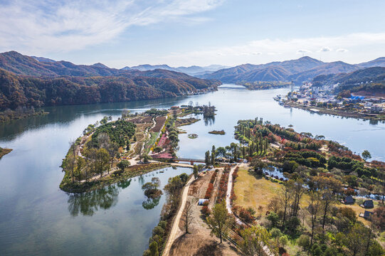 Gapyeong-gun, Gyeonggi-do, South Korea - October 29, 2021: Aerial and autumnal view of Bukhan River and Jarasum Island with maple trees with the background of Nami Island