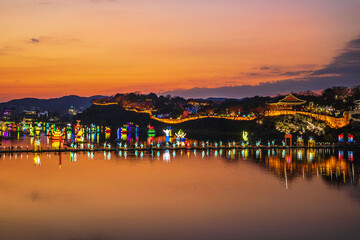 Namgang Yudeung Festival, Jinju-si, Gyeongsangnam-do, South Korea - December 5, 2021: Sunset view of floating platform and sculptures on river against Chokseongnu Pavilion © JinChang