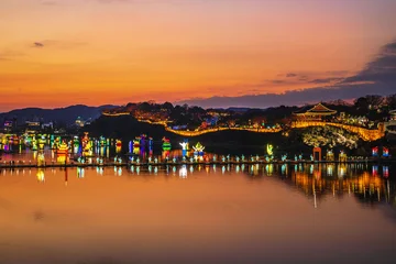 Namgang Yudeung Festival, Jinju-si, Gyeongsangnam-do, South Korea - December 5, 2021: Sunset view of floating platform and sculptures on river against Chokseongnu Pavilion © JinChang