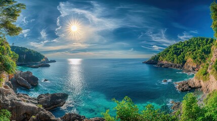 A secluded bay in Phuket at midday, with the sun shining brightly from a clear blue sky