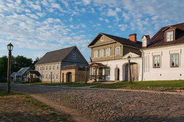 View of historical merchant buildings of estates on the main street of Izborsk Pechorskaya Street on a summer sunny day, Izborsk, Pskov region, Russia