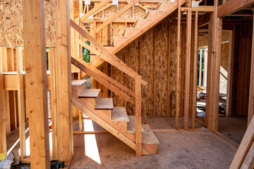 Summer construction season, two story new house build in progress at the framing stage, interior...